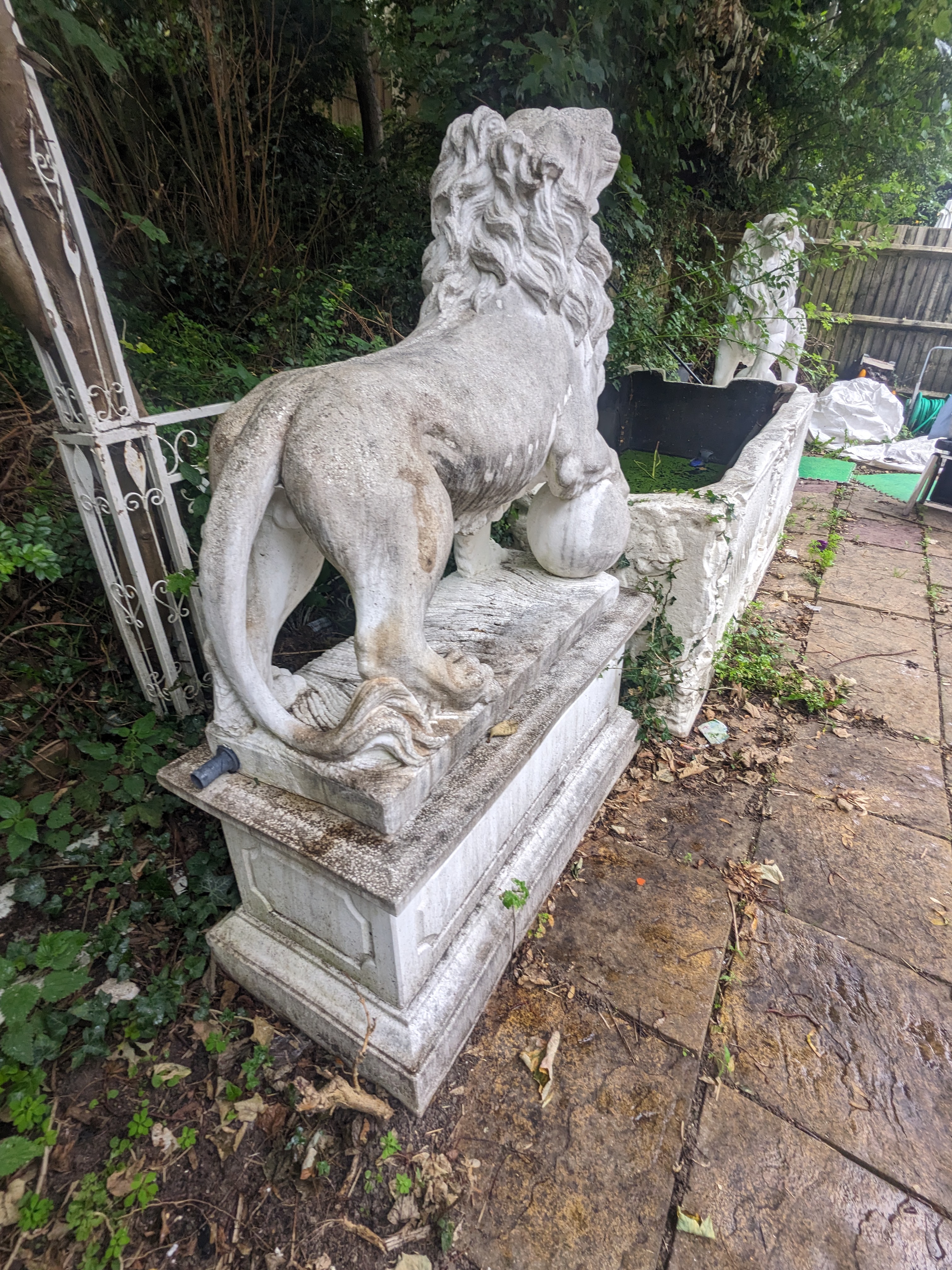 A pair of re-constituted stone models of lions standing upon rectangular plinths, fitted as fountains, Height 160cm., Viewing in Forest Row by arrangement. Purchaser to arrange for removal within one week of the sale dat